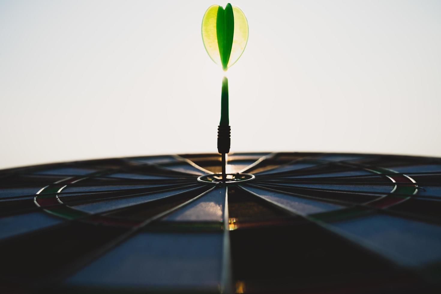 Green darts arrows in the target center on the sky background. Business target or goal success and winner concept. photo