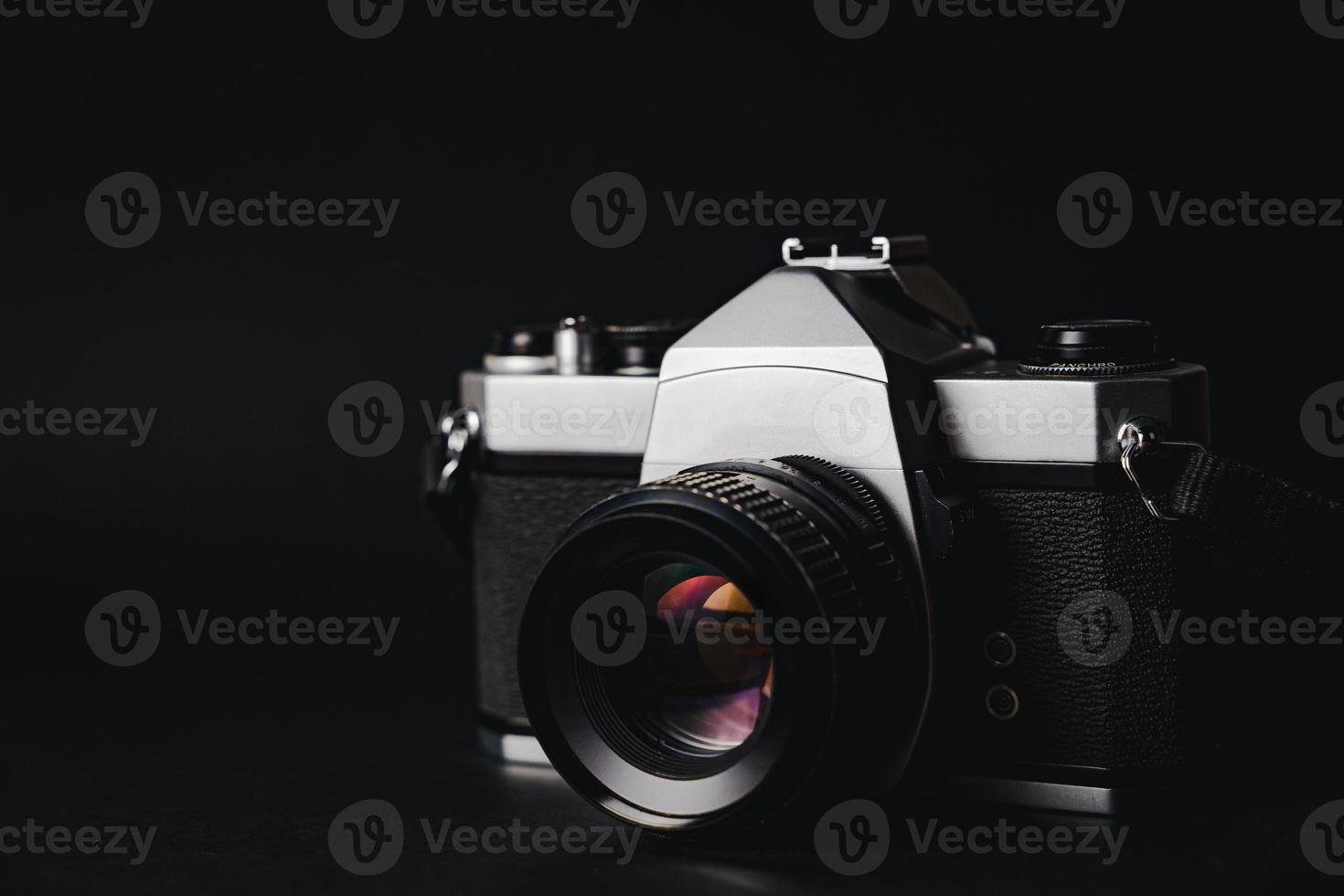 Old 35mm SLR film camera on black background. Flim photography concept. photo