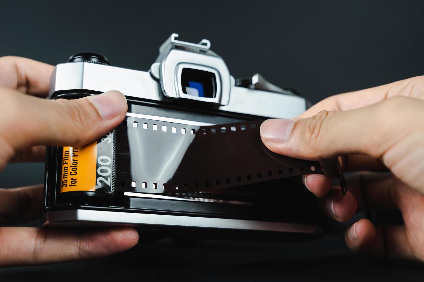 Fotógrafo cargando a mano una película de 35 mm en una cámara de película slr. foto