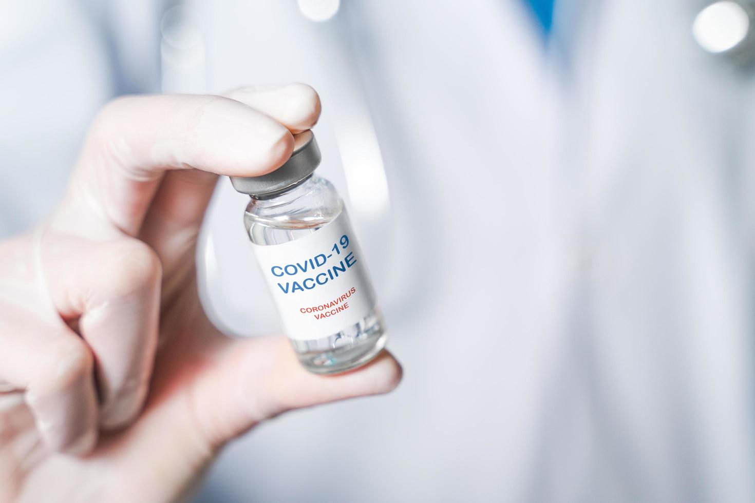 doctor or scientist in laboratory holding a Coronavirus Vaccine in glass bottle. Covid-19 corona virus treatment concept. photo