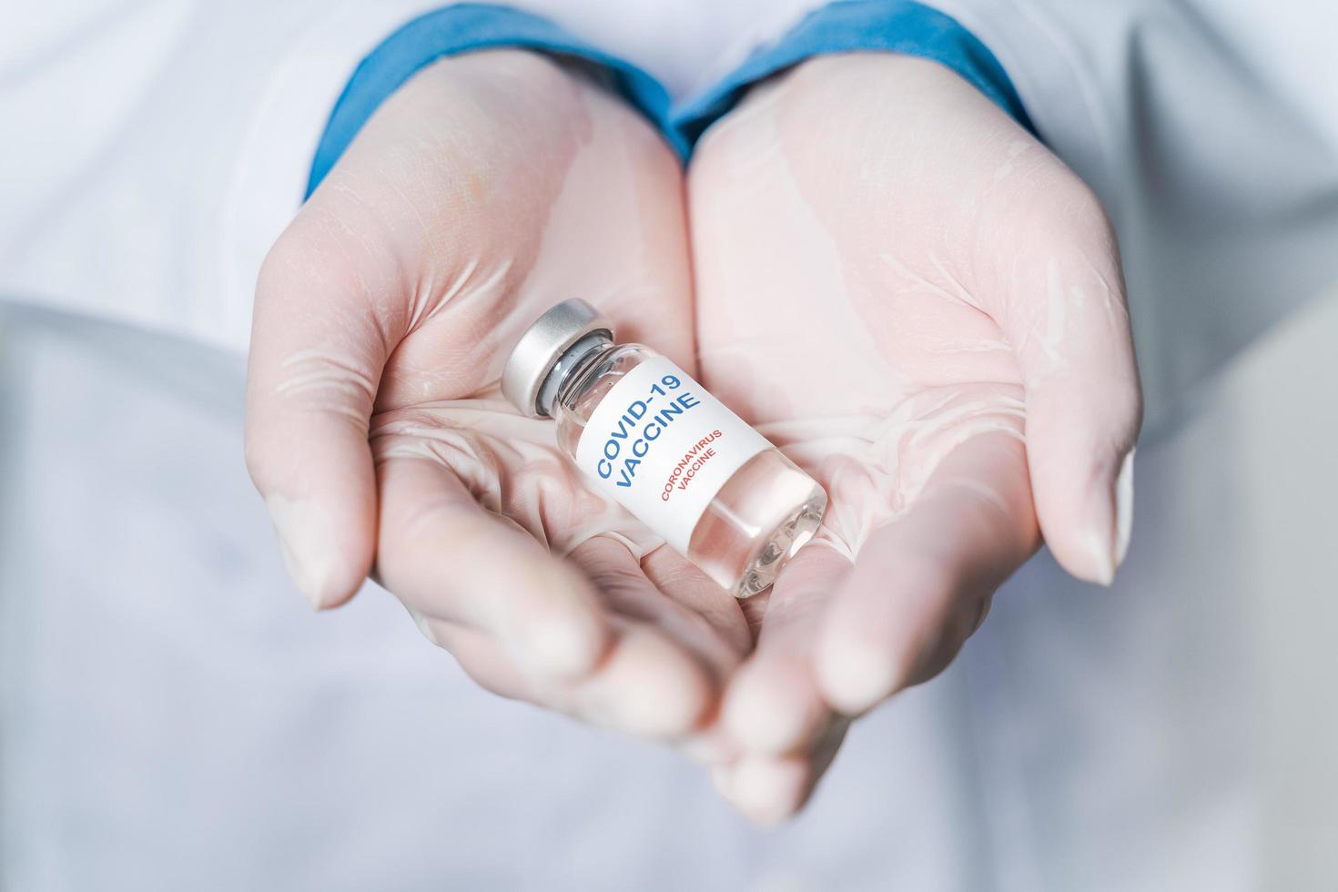 doctor or scientist in laboratory holding a Coronavirus Vaccine in glass bottle. Covid-19 corona virus treatment concept. photo