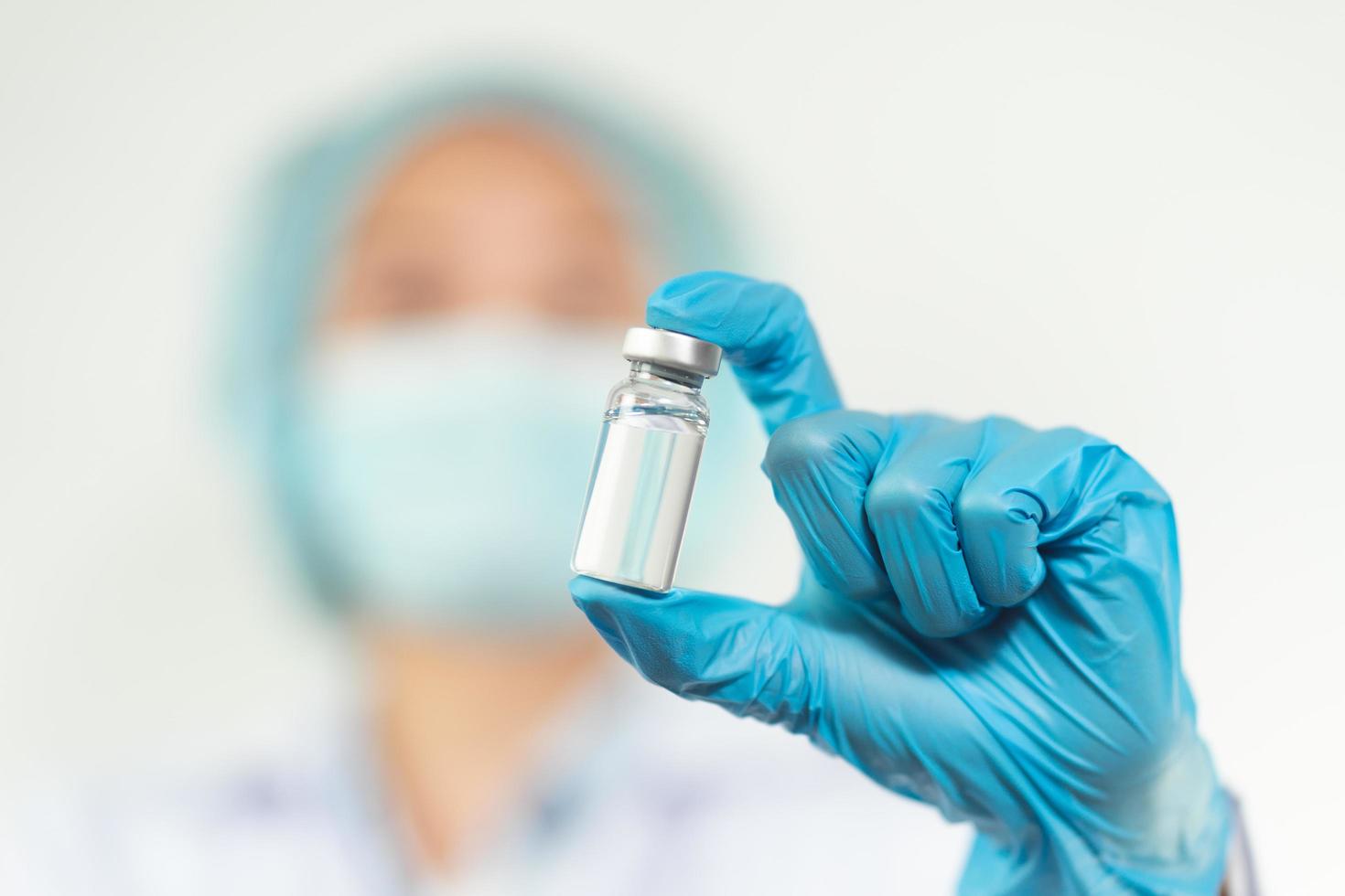 doctor or scientist in laboratory holding a Coronavirus Vaccine in glass bottle. Covid-19 corona virus treatment concept. photo