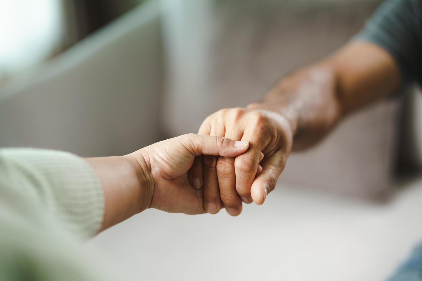 Amiga o familia tomados de la mano durante la alegría del hombre depresivo mental, el psicólogo proporciona ayuda mental al paciente. concepto de salud mental ptsd foto