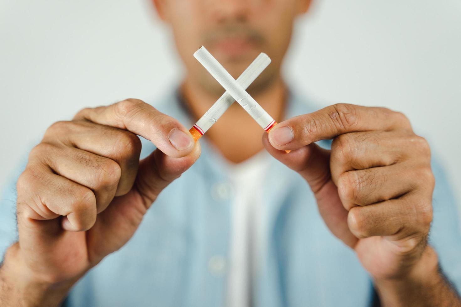 Man hand holding crossed cigarettes. Concept Quitting smoking,World No Tobacco Day. photo