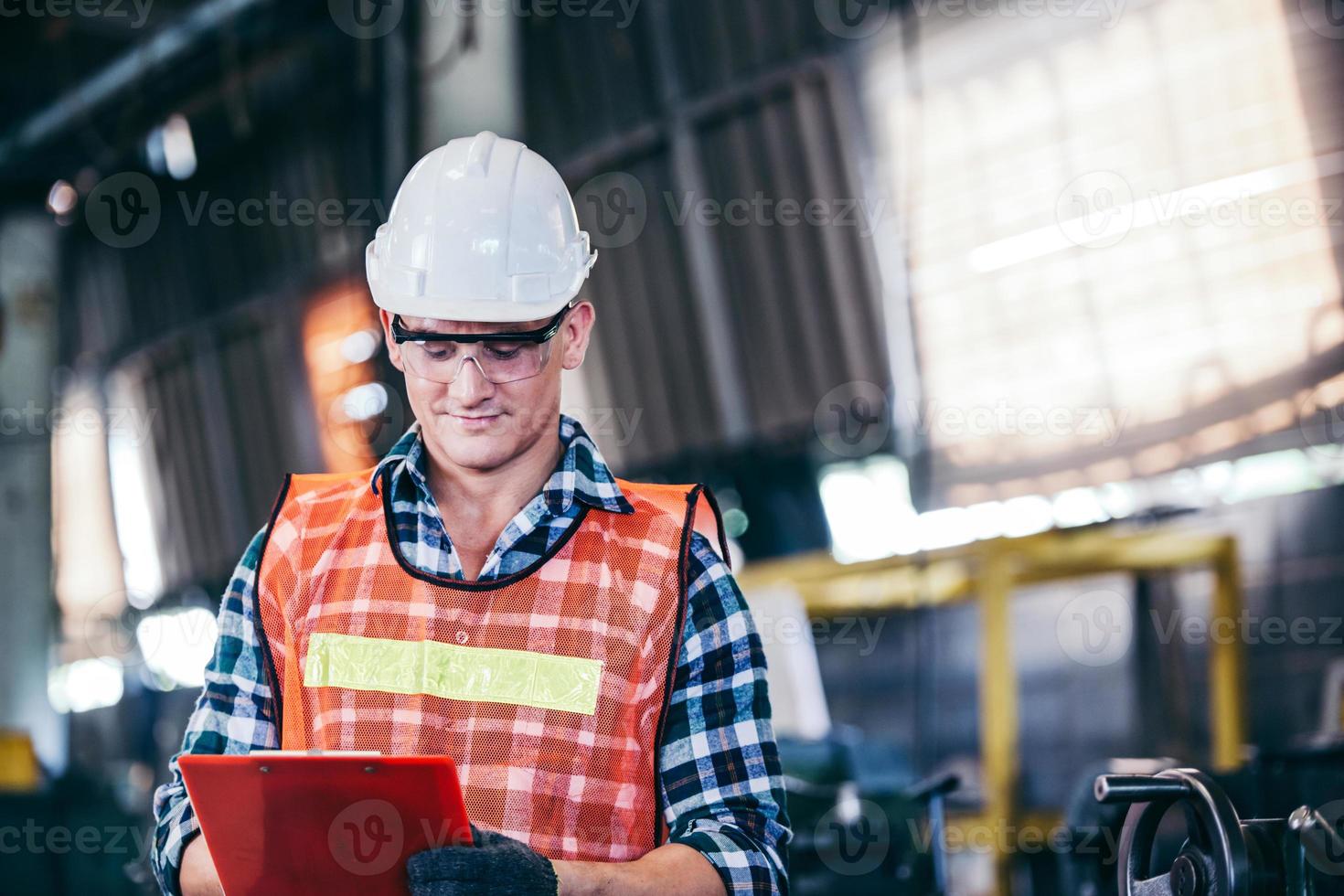 Factory foreman checking on document at construction site photo