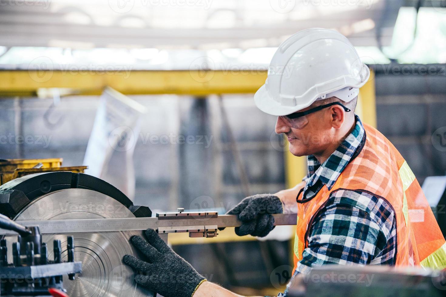 Engineer metalworker working on lathe machine photo