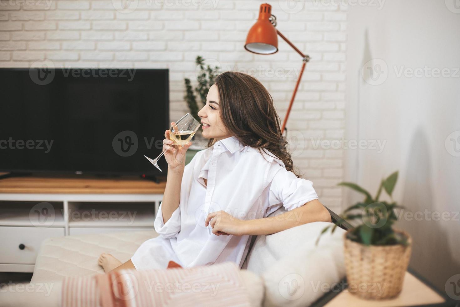 mujer joven con copa de vino en casa. foto