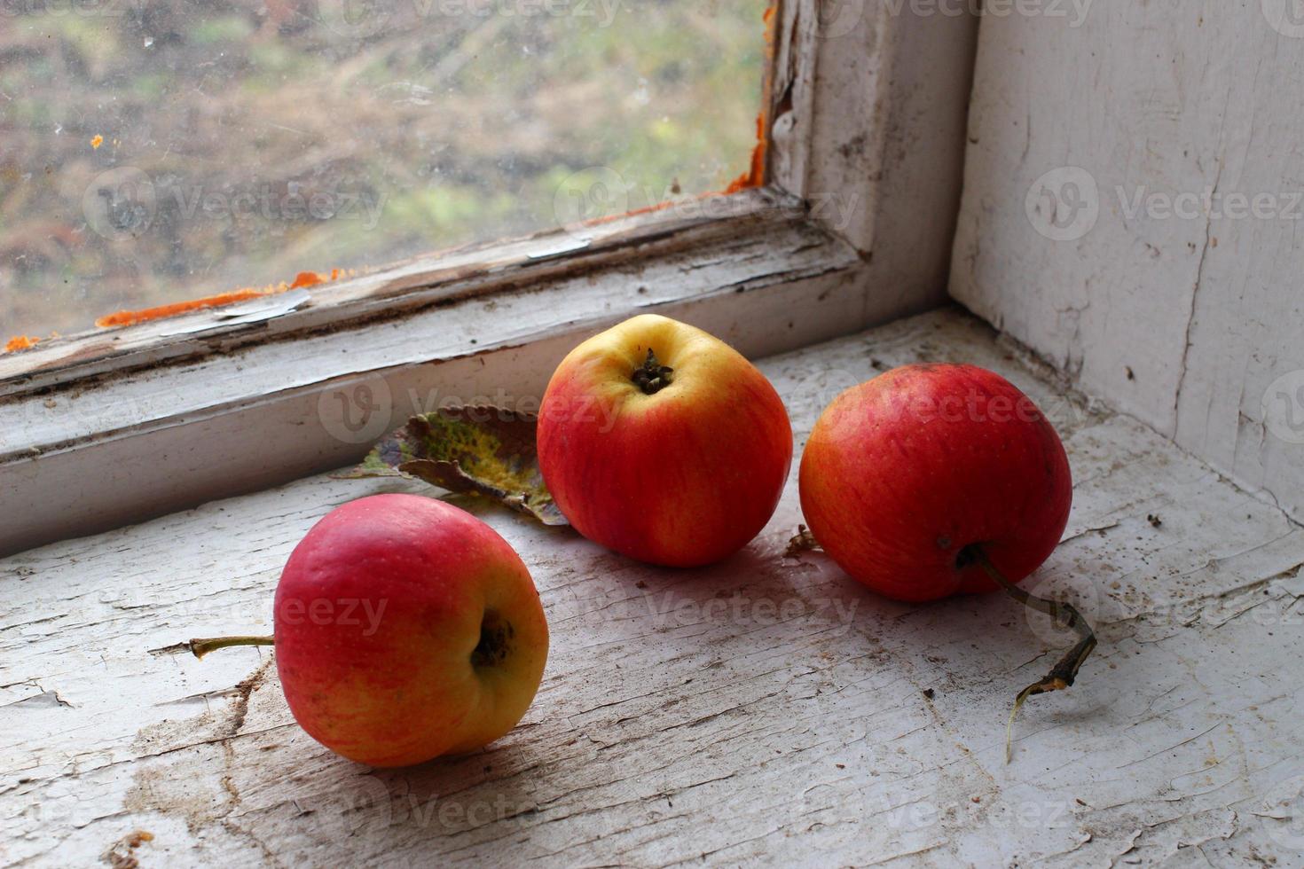 Manzanas rojas en un antiguo alféizar de la ventana foto