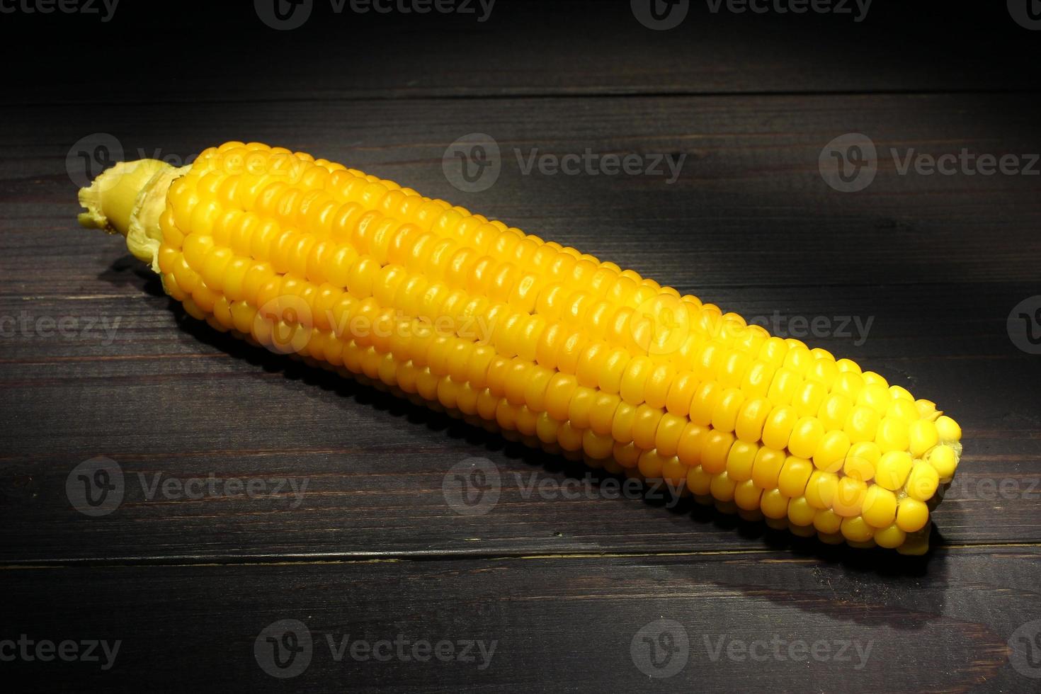 Cobs of yellow boiled corn on a dark background. photo