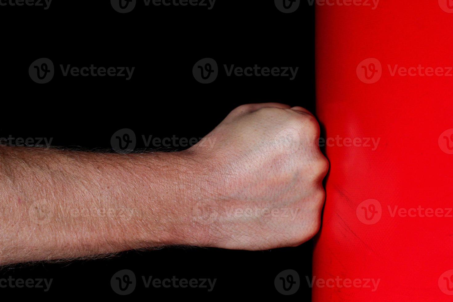 Fist punching a punching bag. Symbol of aggression and strength. photo