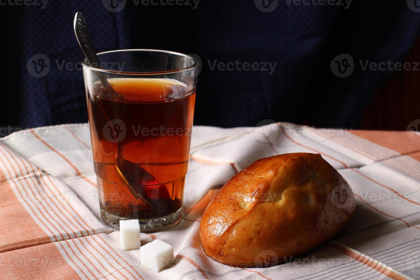 Bun and tea. Simple breakfast. photo