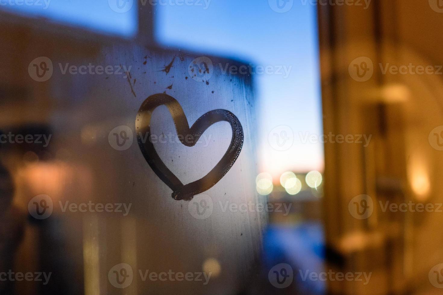 Drawing heart on window in winter photo