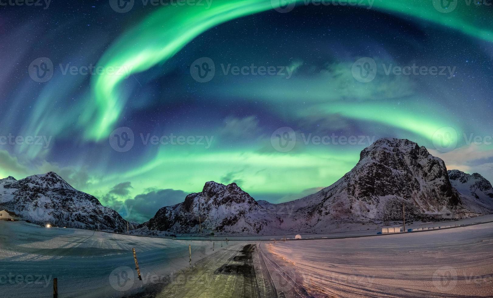 Northern lights explosion on snowy mountain range photo