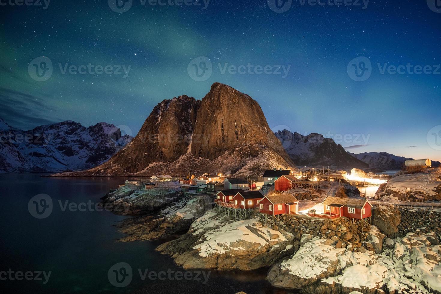 Aurora boreal sobre la montaña en el pueblo de pescadores de Hamnoy foto