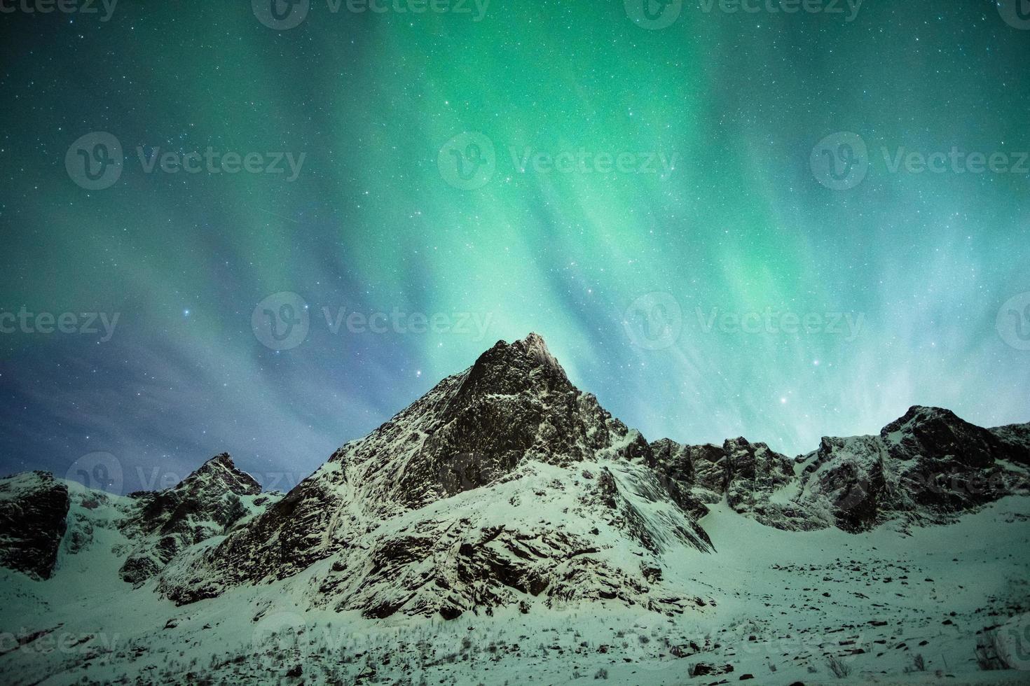 Aurora borealis explosion on snow mountain photo