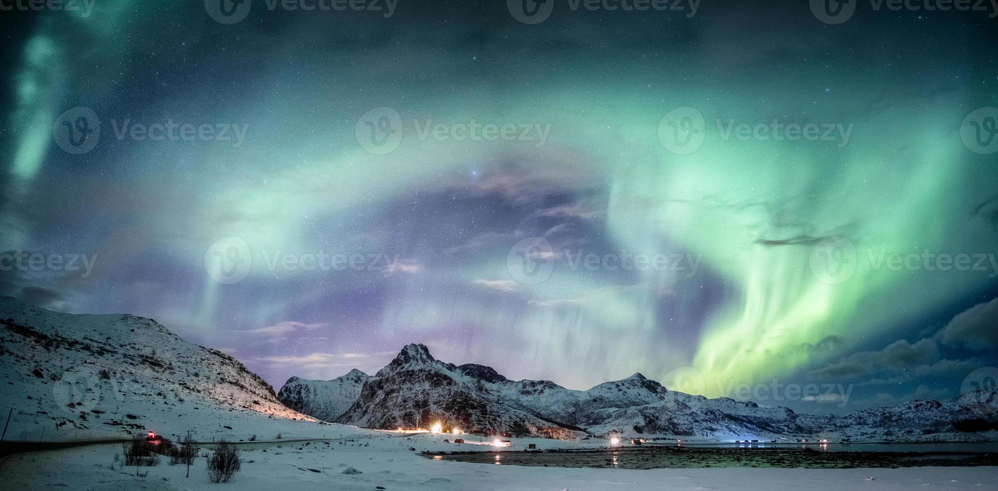 Northern lights explosion on snowy mountain range photo