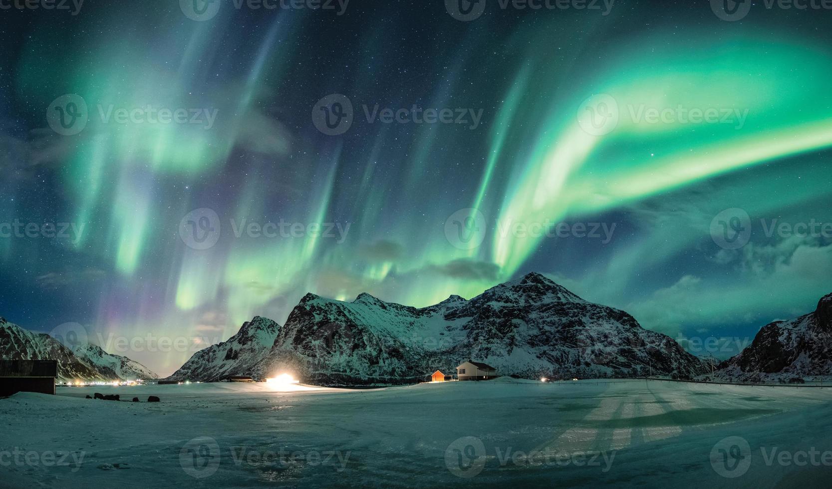 Aurora borealis or Northern lights over snow mountain on coastline photo