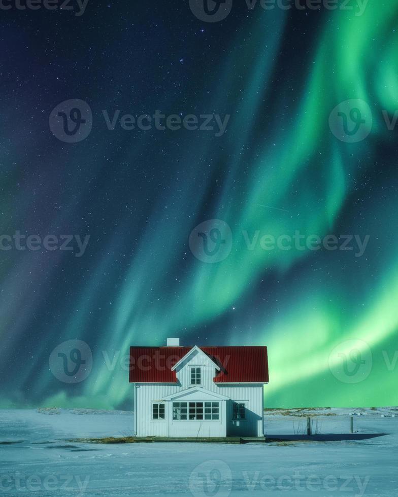 Aurora boreal sobre la casa blanca sobre la nieve en invierno foto