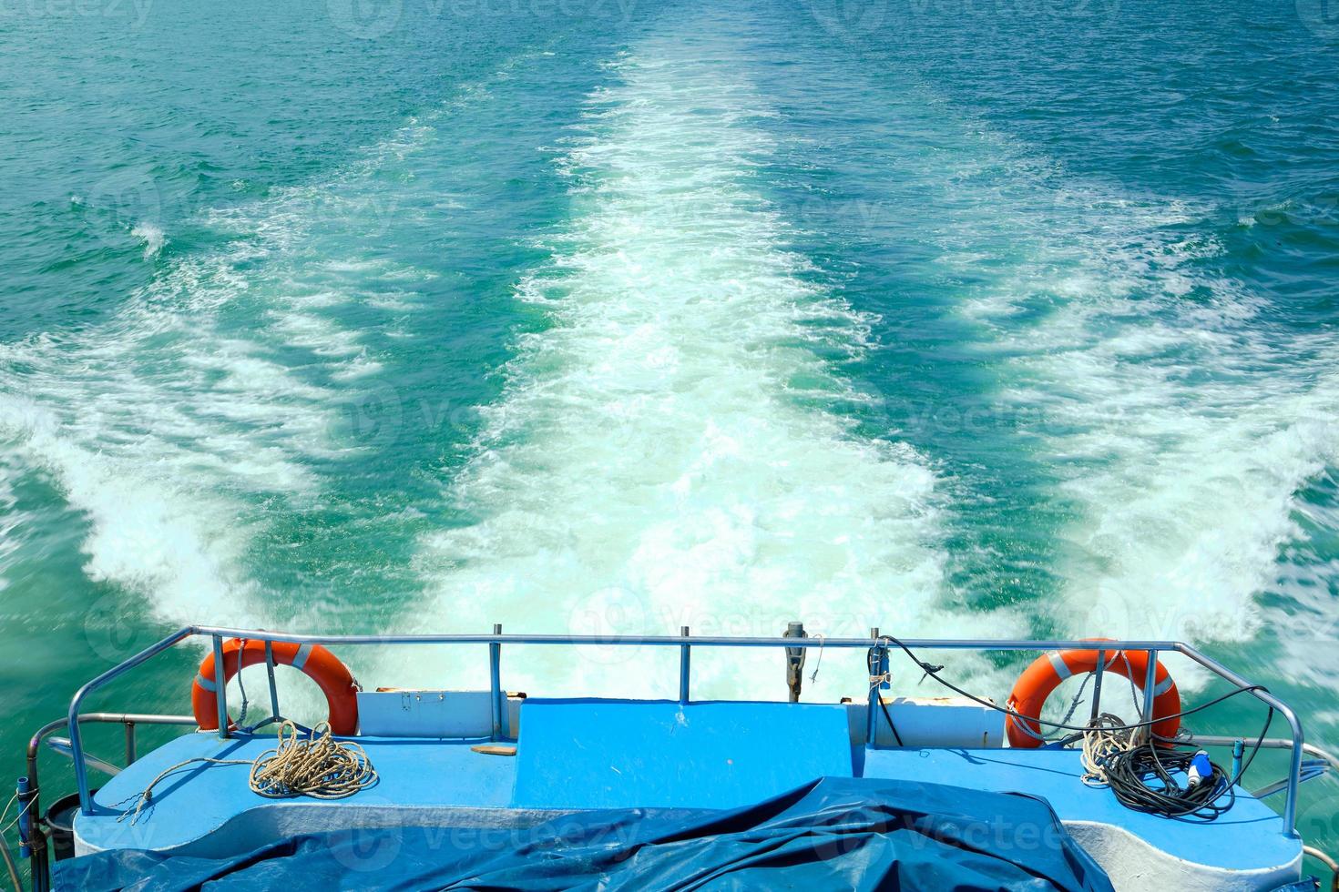 White bubbles and splashes of waves on the ferry stern. Holiday traveled in sea. The ship was moving fast in the view of the ocean and nobody on the deck. photo