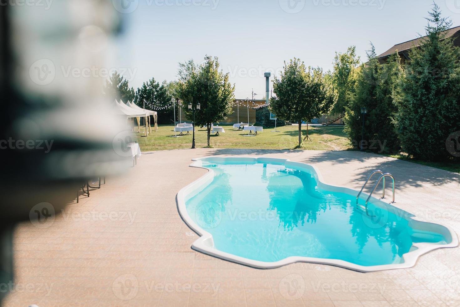 blue outdoor pool in the garden surrounded by trees photo