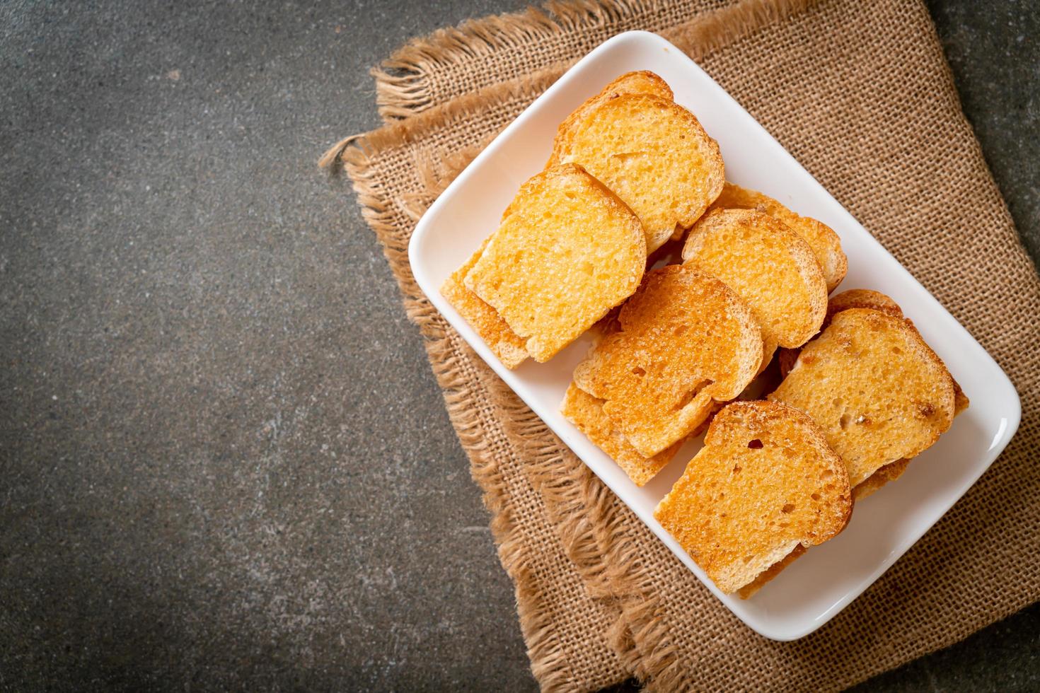 Baked crispy bread with butter and sugar on plate photo