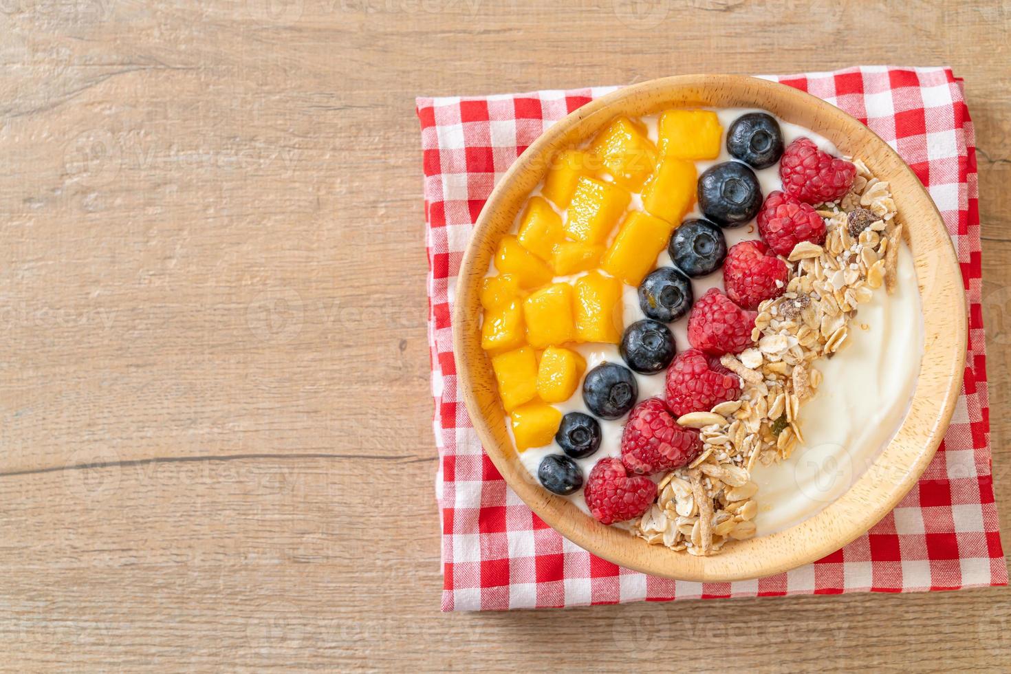 tazón de yogur casero con frambuesa, arándano, mango y granola - estilo de comida saludable foto