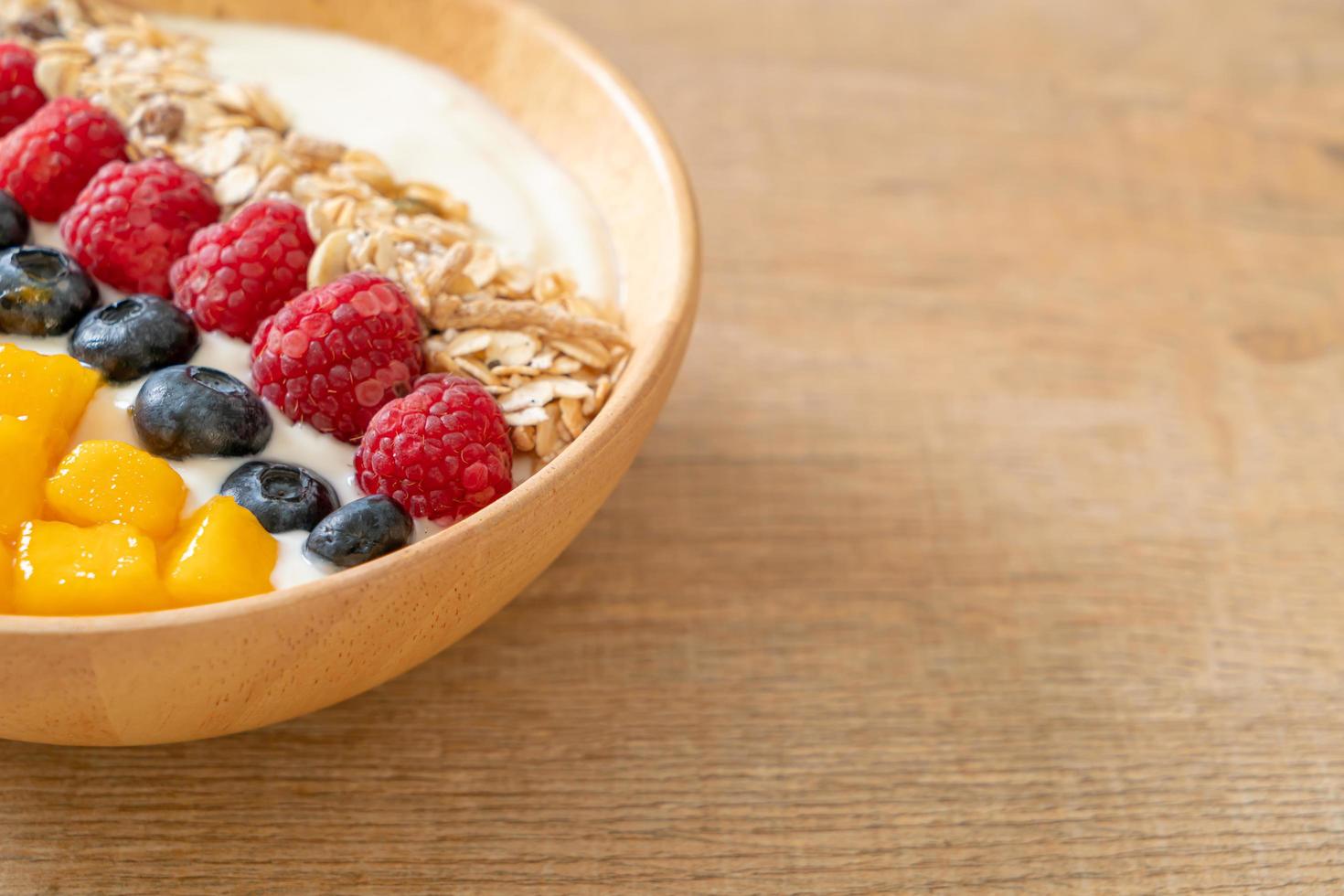 tazón de yogur casero con frambuesa, arándano, mango y granola - estilo de comida saludable foto