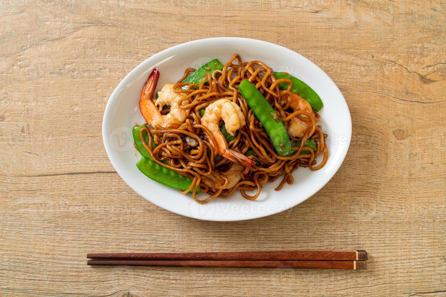 fideos yakisoba salteados con guisantes y camarones - estilo de comida asiática foto