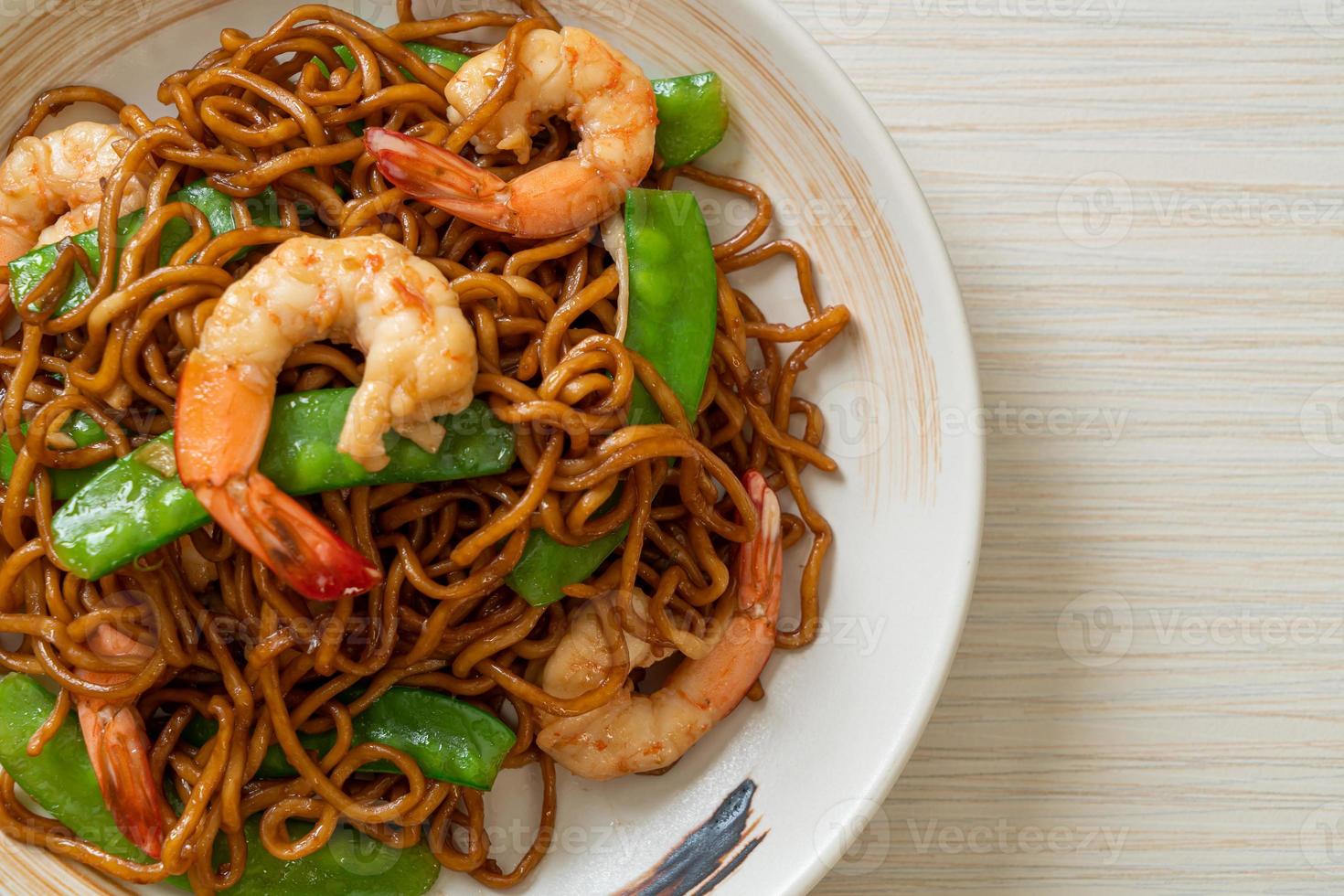 Stir-fried yakisoba noodles with green peas and shrimps - Asian food style photo