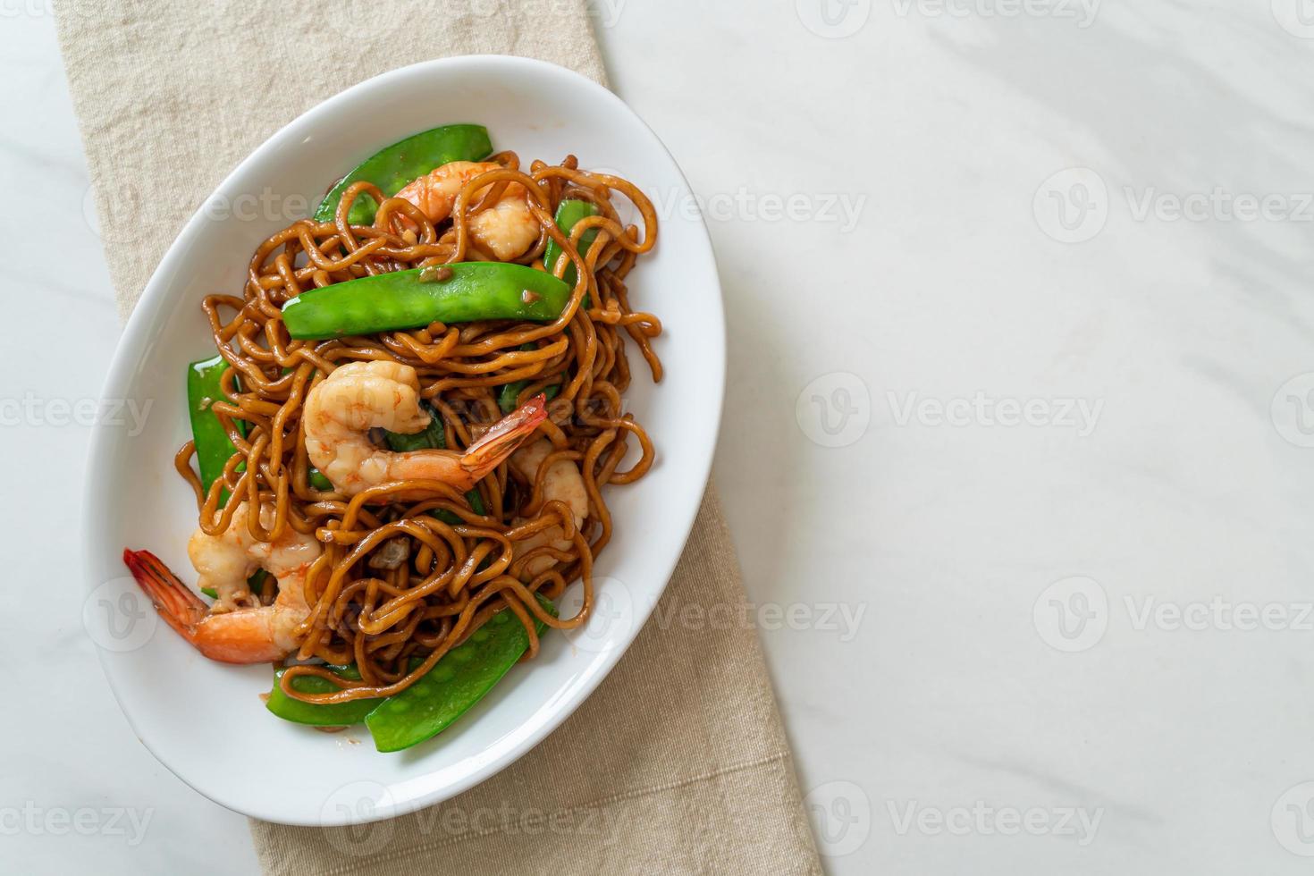 fideos yakisoba salteados con guisantes y camarones - estilo de comida asiática foto