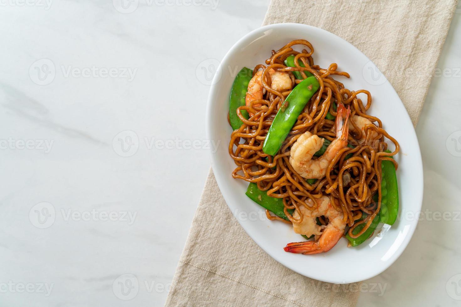 Stir-fried yakisoba noodles with green peas and shrimps - Asian food style photo