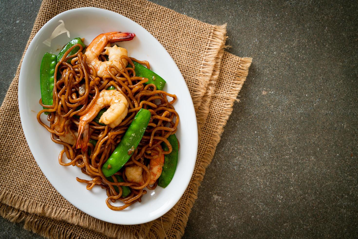 Stir-fried yakisoba noodles with green peas and shrimps - Asian food style photo