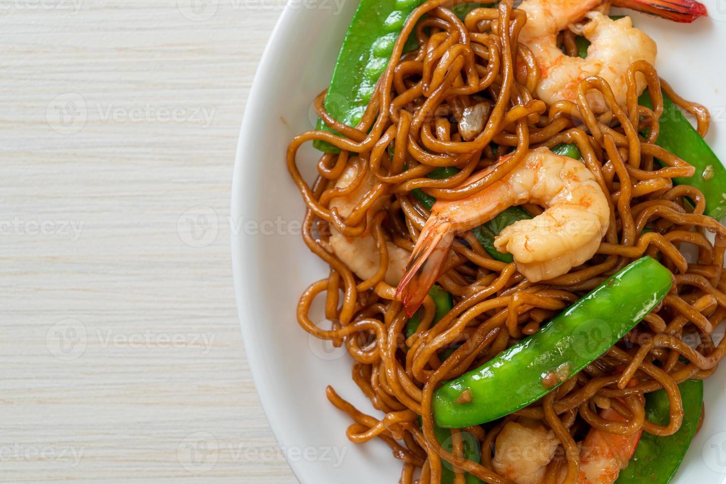 fideos yakisoba salteados con guisantes y camarones - estilo de comida asiática foto