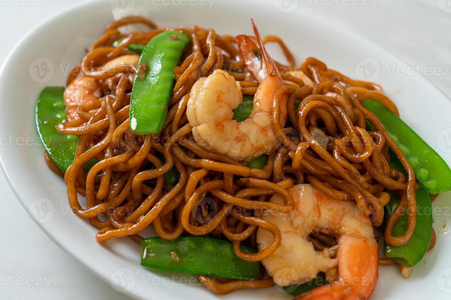 fideos yakisoba salteados con guisantes y camarones - estilo de comida asiática foto