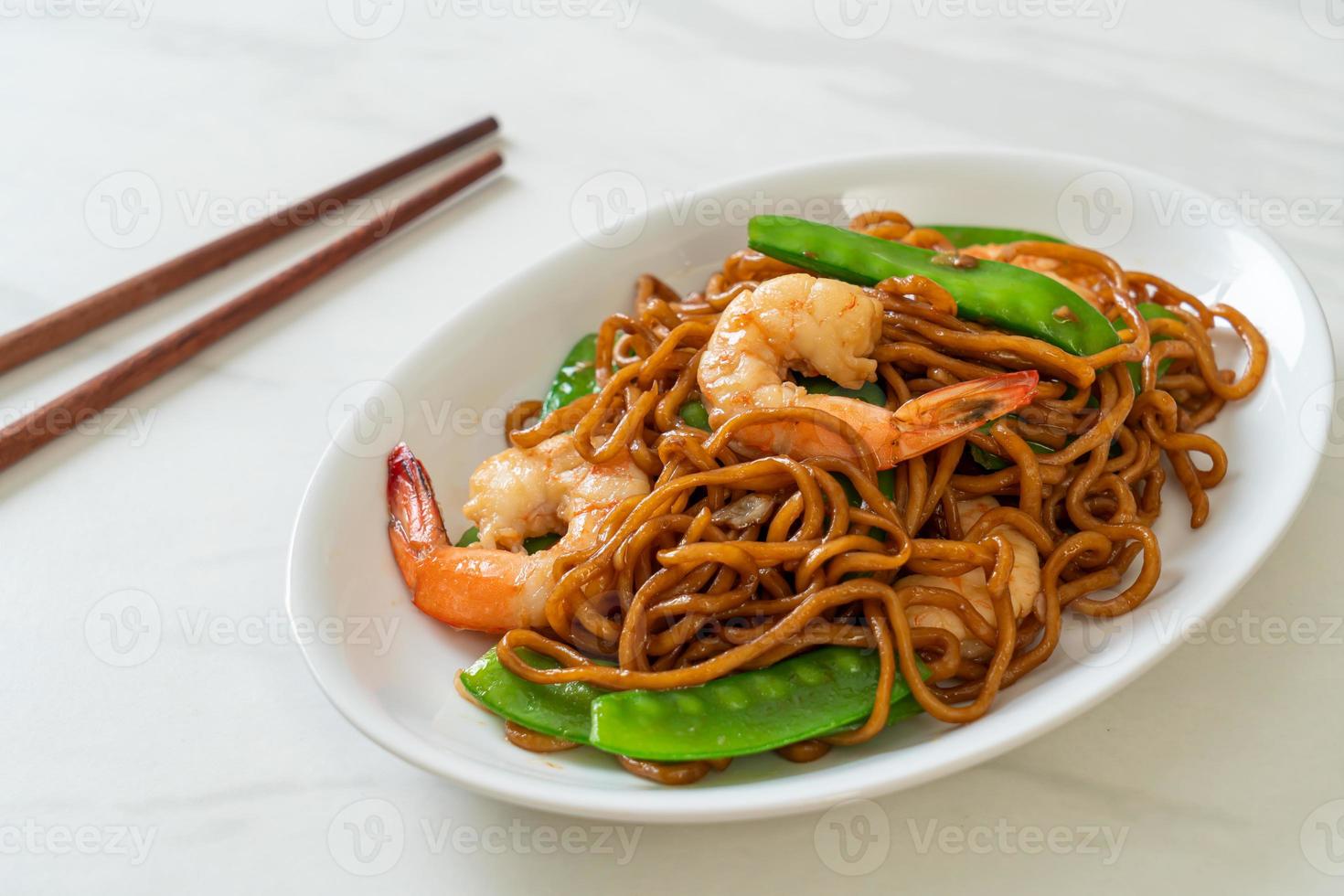 Stir-fried yakisoba noodles with green peas and shrimps - Asian food style photo