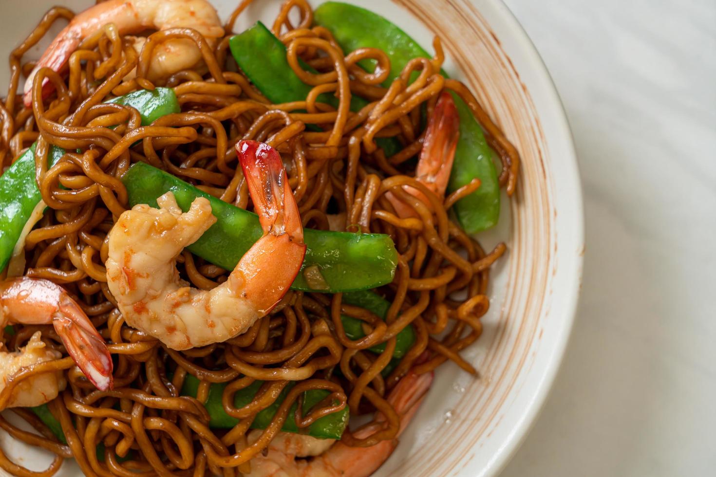 Stir-fried yakisoba noodles with green peas and shrimps - Asian food style photo