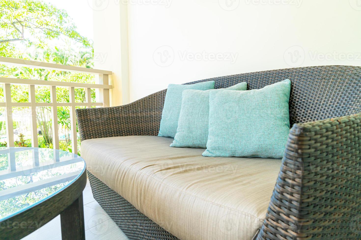 Cómoda decoración de almohadas en una silla de patio en el balcón foto