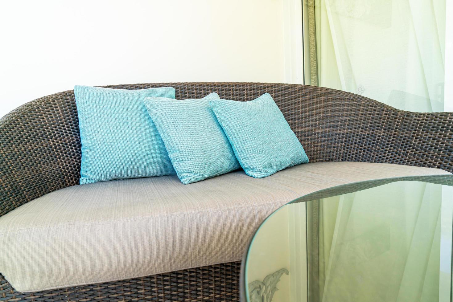 Cómoda decoración de almohadas en una silla de patio en el balcón foto