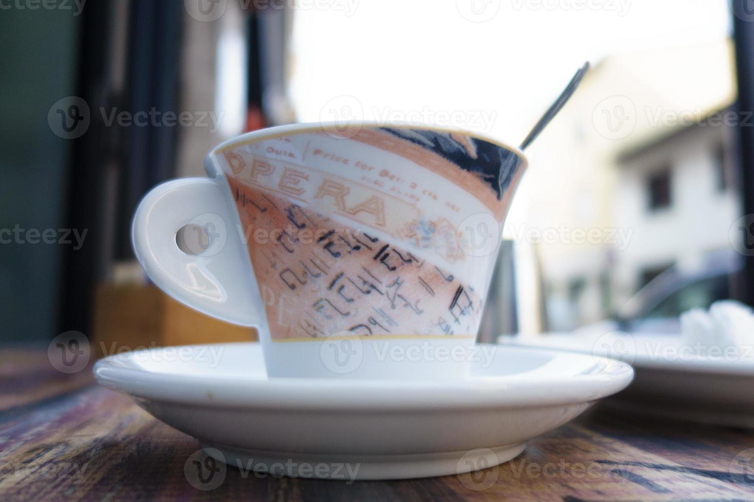 Taza blanca con sobras de café en la mesa foto