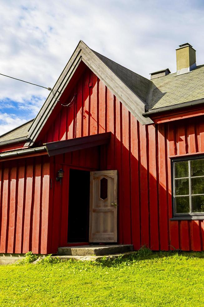Hermosa cabaña de madera roja en la colina en la naturaleza de Noruega. foto