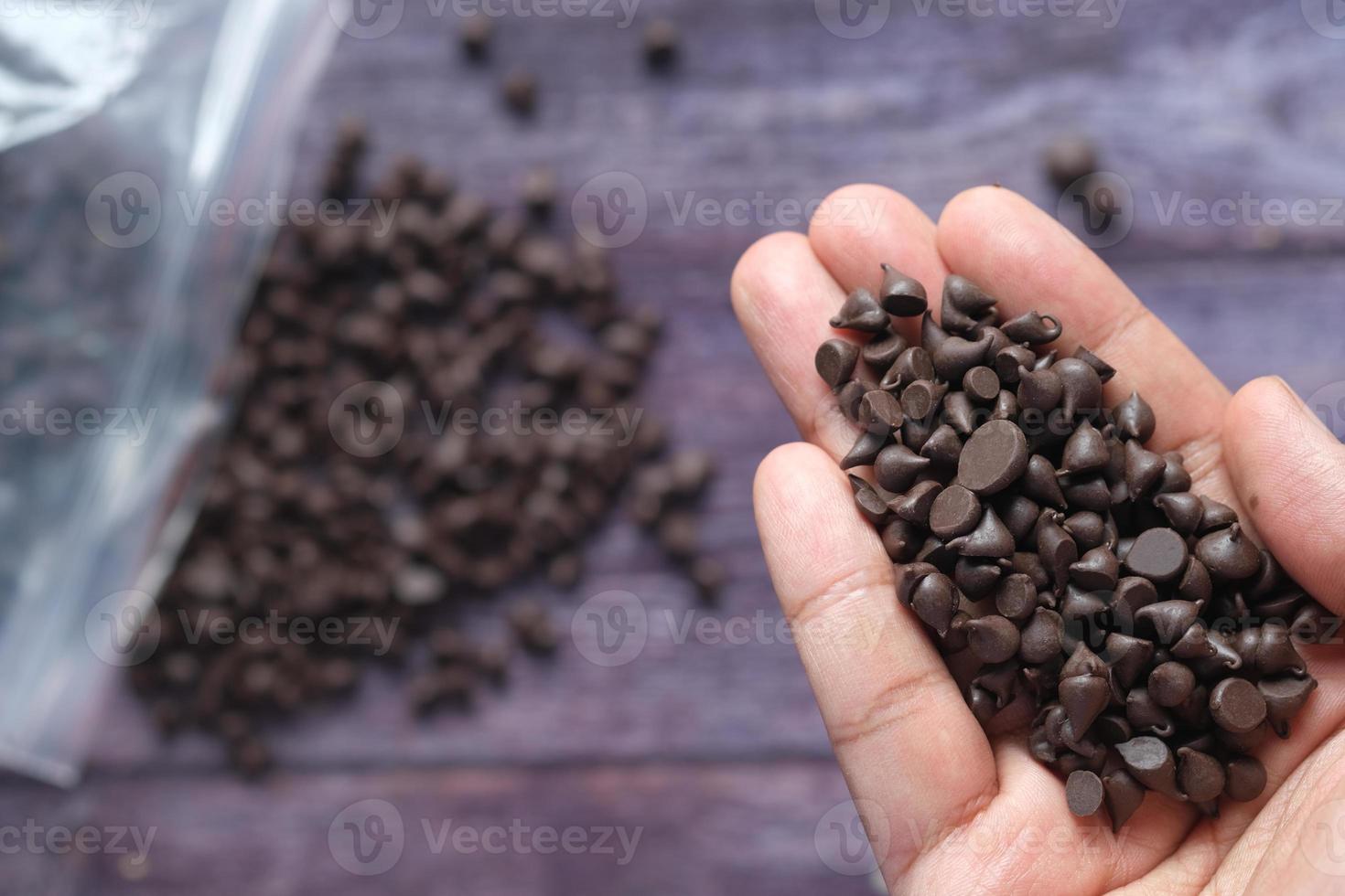 Chocolate chips on palm of hand top view photo