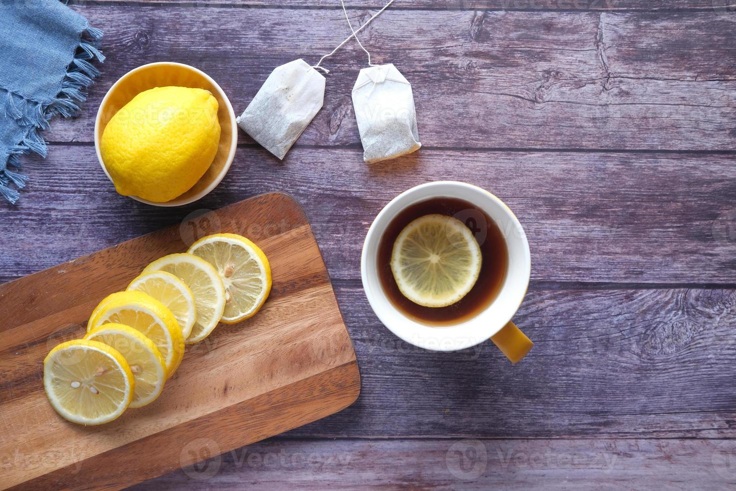 Top view of lemon tea and slice of lemon on wooden background photo