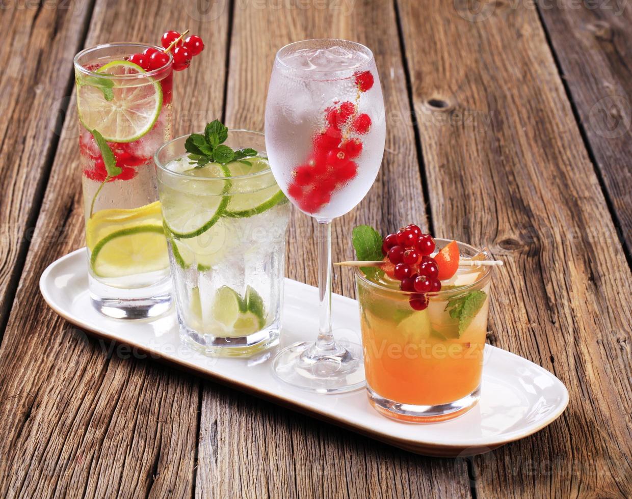 Glasses of iced drinks garnished with fresh fruit photo