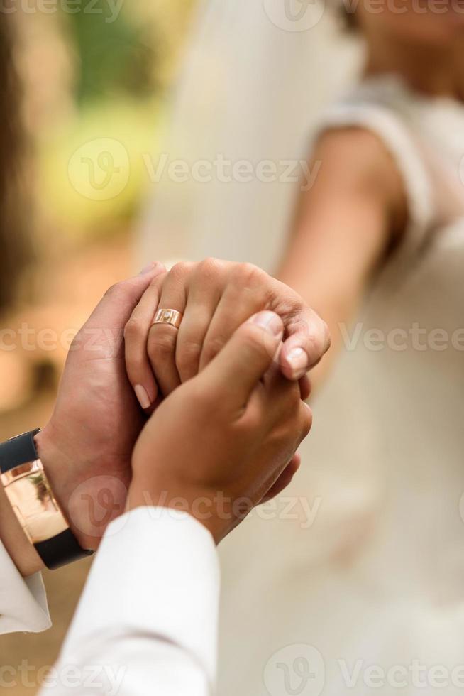 the groom holds the bride's hand photo