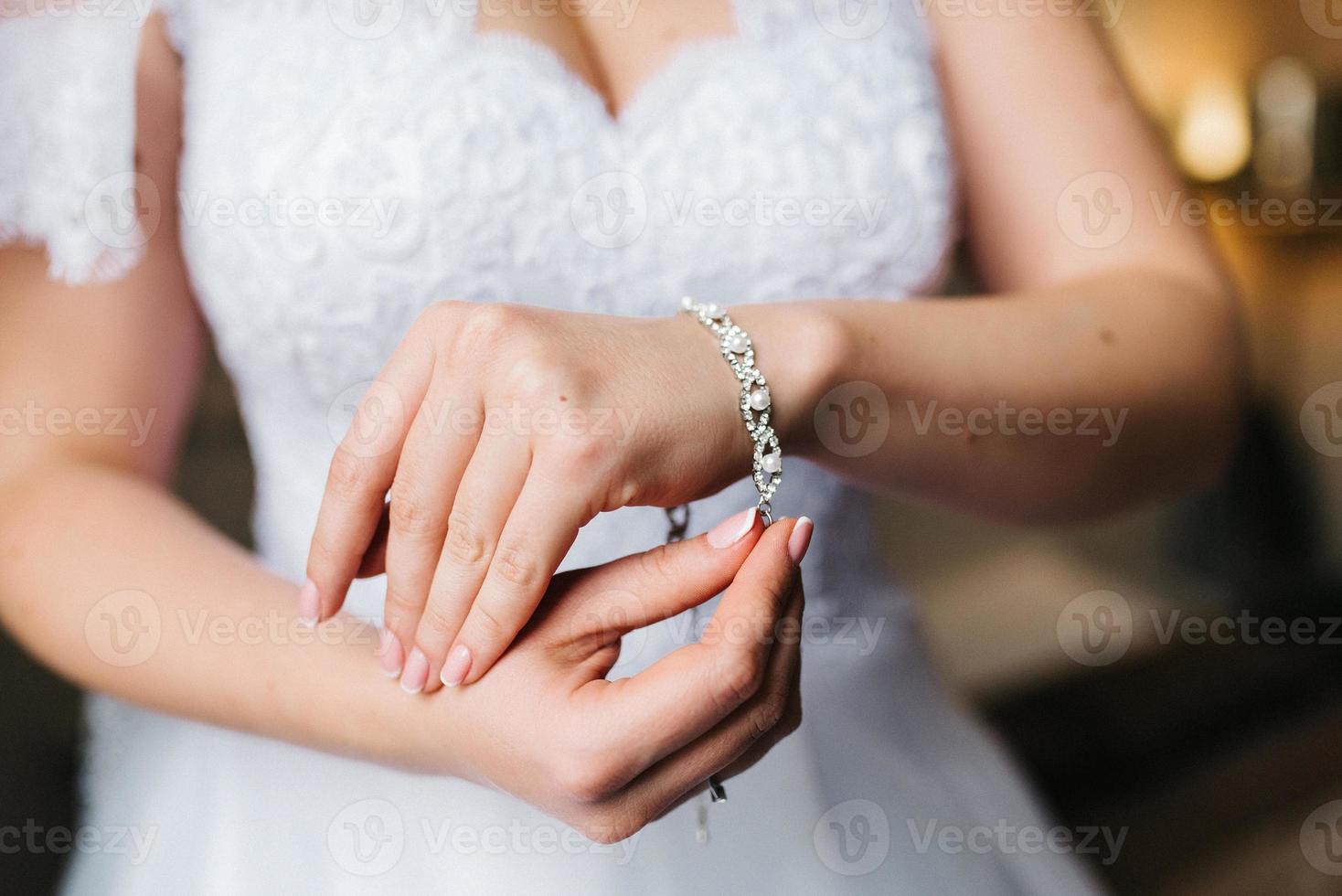 the bride wears a wedding bracelet on her left hand photo