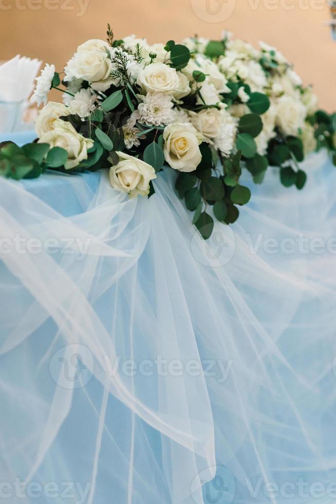 The presidium of the newlyweds in the banquet hall of the restaurant is decorated with candles and green plants photo