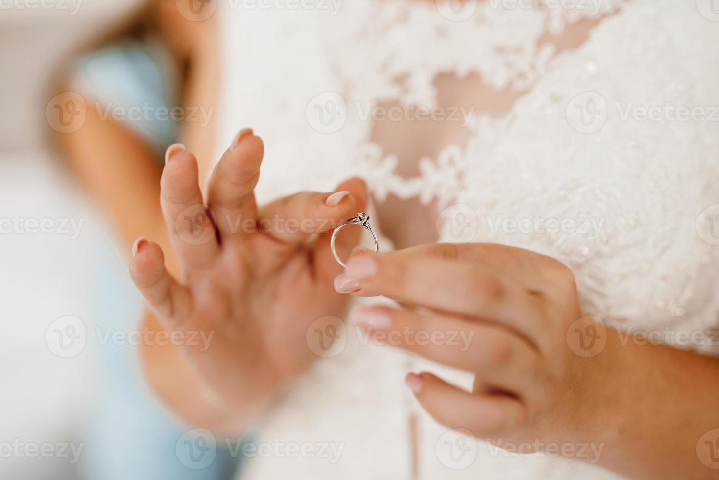 the bride gently touches her dear engagement ring photo