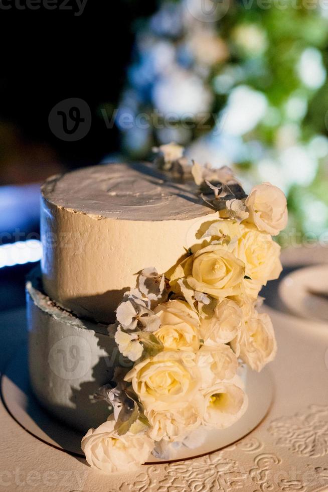 wedding cake on a wooden bench against a waterfall background photo