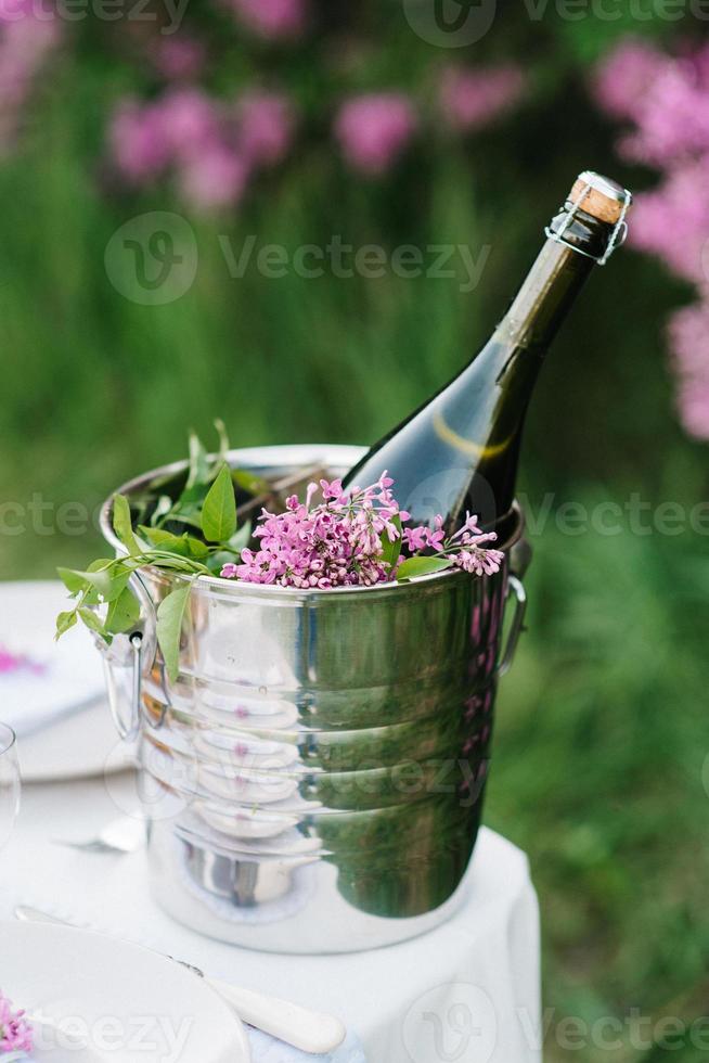 a bottle of wedding champagne in an ice bucket on a table photo