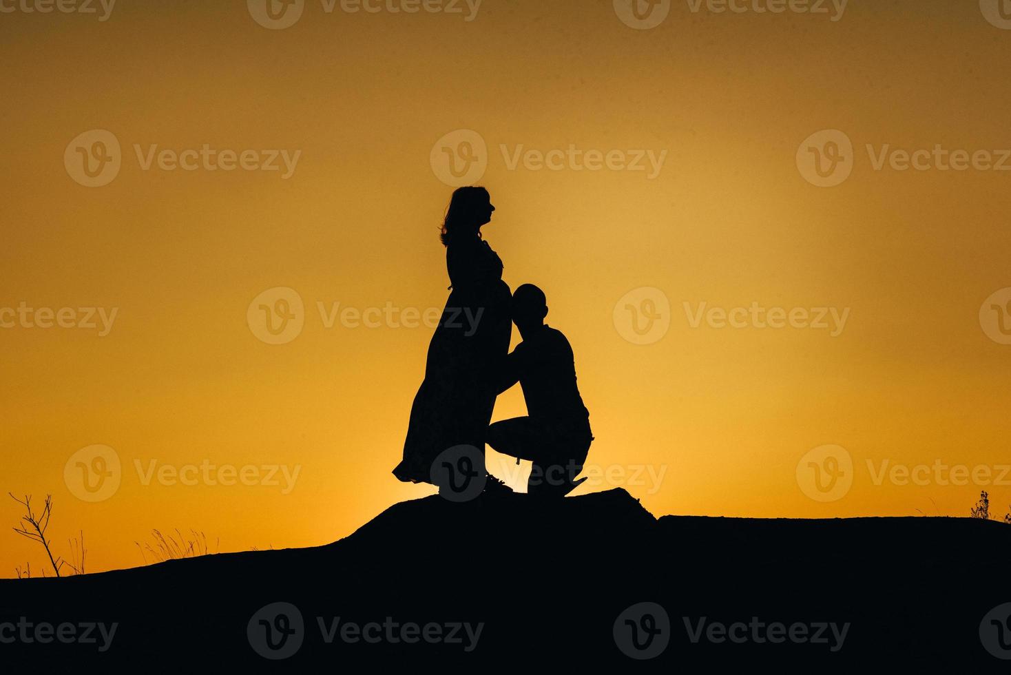 silhouettes of a happy young happy family against an orange sunset photo